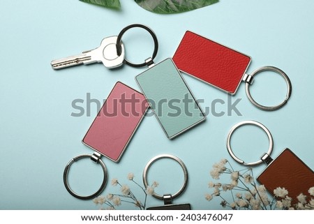 Metal and leather keychains. Colorful one side leather; Square, rectangle and circle shaped key rings. Concept shots, photos taken specially for e-commerce sales. Blue background.