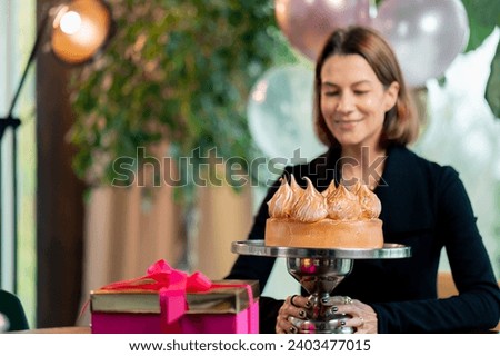 portrait of happy birthday girl looking birthday cake during party in restaurant
