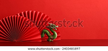 Lunar New Year 2024 background. Chinese dragon with red paper fans on red background.