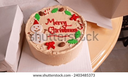 Merry Christmas Text, Ideas for Making Tasty Carved Cakes in the Kitchen for Gifts. New Year Celebration Short Cake Decorated With Sugar and Butter Cream. Creamy Dessert Festival Milk Chocolate Cake