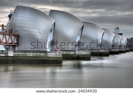View of the Thames Barrier, showing six of the nine concrete piers. Thames Barrier is the world's second largest movable flood barrier, located downstream of central London in the area of Silvertown. Royalty-Free Stock Photo #24034930