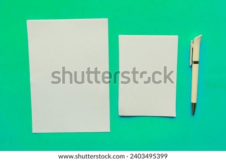 Two white mockup blanks and pen on blue background. Flat lay, top view, copy space