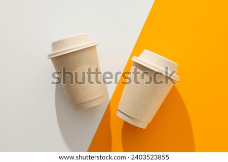 Paper cups with lids on a white-orange background