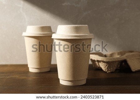 Paper cups with lids on a wooden table