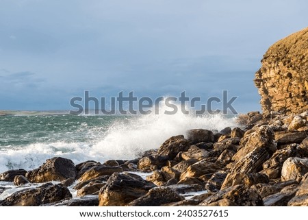 Scenic cliffs during a storm with foamy waves near Dunnet Head, in Caithness, on the north coast of Scotland, the most northerly point of the mainland of Great Britain Royalty-Free Stock Photo #2403527615