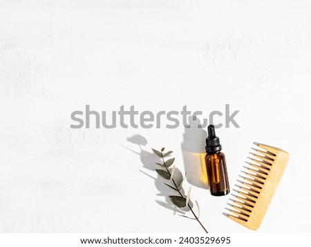 Essential oil for hair care with wooden hair comb and bamboo comb on white background. Top view, flat lay. copy space. Self care, hair treatment concept. Royalty-Free Stock Photo #2403529695