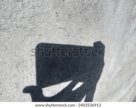 The shadow on the wall is someone taking a picture from a smartphone.