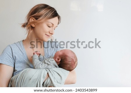 Mother and baby. Loving mom spending time with her little 2 weeks old child at home. Image of bonding mother and baby, healthy physical and mental development of child, happy maternity and family. Royalty-Free Stock Photo #2403543899