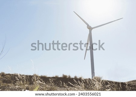 Panoramic view of wind farm or wind park, with high wind turbines for generation electricity with copy space. Green energy concept.A photo of a wind turbine in a field, renewable energy stock photo.