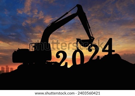 Concept happy new year 2024,crawler excavator silhouette with lift up bucket .On sunrise backgrounds