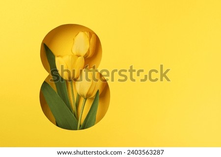 8 March greeting card. Paper cut Eight made of yellow background and fresh spring flowers bouquet of yellow tulips. Greeting card for Womens Day on March 8 Flat lay top view. International Womens day Royalty-Free Stock Photo #2403563287