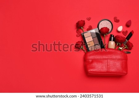 Cosmetic bag with make up products and roses on red background. Valentine's day celebration