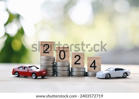 close up stack of coin, 2024 wooden text block and toy car on wood table, saving and manage money for transport, transportation insurance business technology, economic crisis risk and problem concept