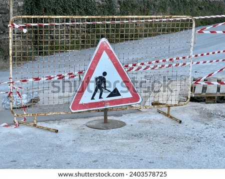 Road construction sign with barriers indicating work in progress. Daytime Road Construction Warning Sign