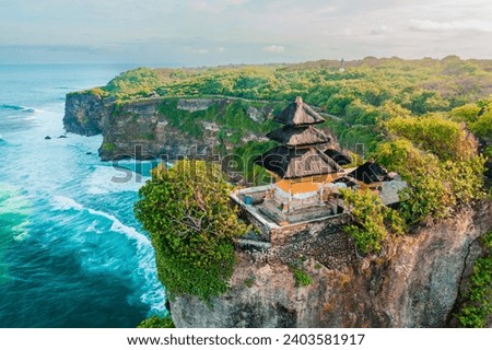 Bali's Most Iconic Landmark and popular tourist attraction Uluwatu Temple one of six key Bali temple perched on top mountain cliff on background amazi Royalty-Free Stock Photo #2403581917