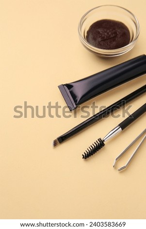Eyebrow henna and tools on beige background. Space for text