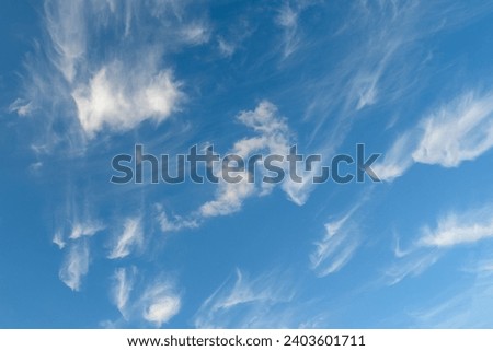 It is blue sky background. This is blurred view of small white Spindrift clouds in blur blue sky. It is fairy cloud in sky. It's asunny day.
