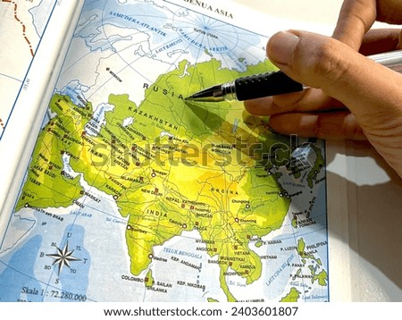 Ballpoint pen points to the country of Russia on the map