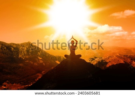 Woman meditating in mountains at sunset, back view