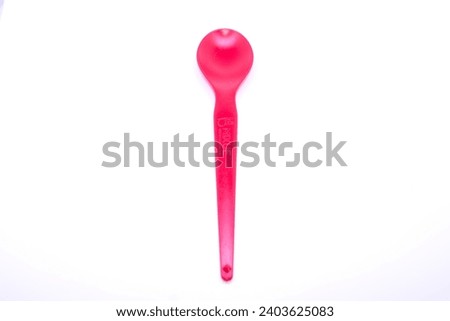 Red plastic spoon. On isolated white background