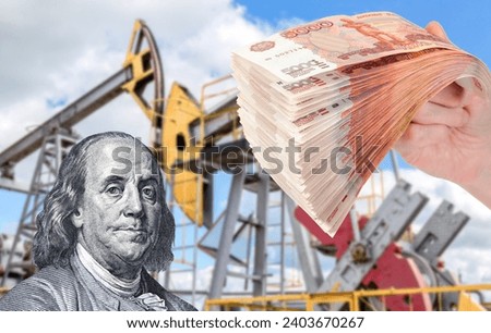 Russian roubles in the hand and Behjamin Franklin portrait against the oil pump jack extraction machine. Buying and selling oil. Oil industry equipment and finace