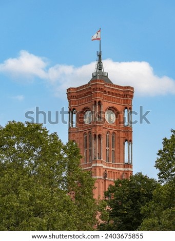 A picture of the tower of the Rotes Rathaus or Berlin Red City Hall above the treetops.