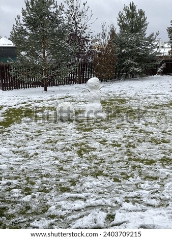 A snowman standing on green grass 