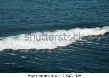 Ocean waves crashing on the beach in a sunny morning, dramatic blue sky on a beautiful beach