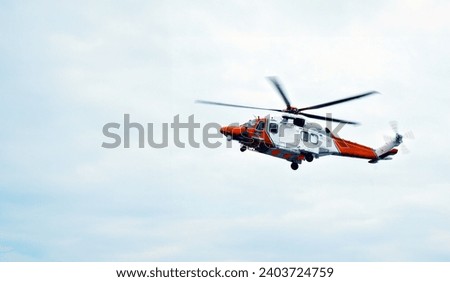 Search And Rescue Operations At Sea. Red Rescue Helicopter. Emergency Response Team. Emergency Accident On Board Merchant Ship. Helicopter Training  And Simulation Ship In Distress Royalty-Free Stock Photo #2403724759
