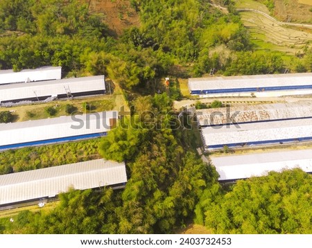 Industrial Photography Landscapes. Aerial view of Big warehouse storages in the middle of the forest, Located in Cikancung, Bandung - Indonesia. Aerial Shot from a flying drone.