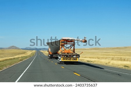 Highway, South Dakota, USA - September 30 2023: Oversize load transportation of wind turbine blade. Environment and logistics concept Royalty-Free Stock Photo #2403735637