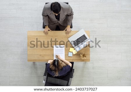 Young woman signing important document at a table. Professional business setting. Determination, empowerment, and inclusivity concept. Diversity and inclusion in the workplace. Top View