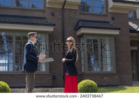 Blonde woman and real estate agent in new cottage residence. Businesswoman client observes offer from real estate agency