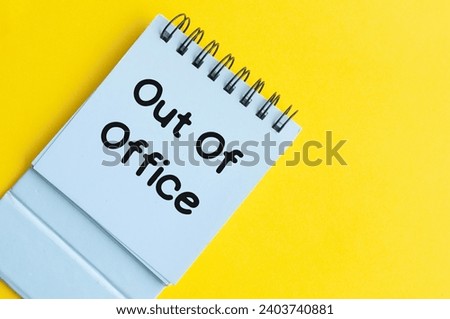 Out of office text on notepad with yellow background. Out of office concept