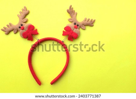 cute Christmas headbands with christmas reindeer horns isolate on a yellow backdrop. concept of joyful Christmas party,New year is coming soon, festive season decoration with Christmas elements