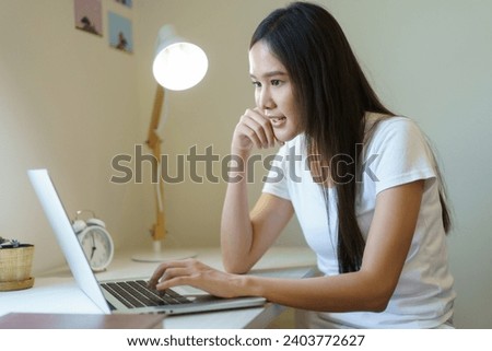 Asian beautiful woman checking e-mail and browsing the internet on laptop - notebook computer in morning. Woman working from home. Modern working lifestyles concept.