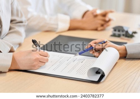 A woman signing a real estate contract