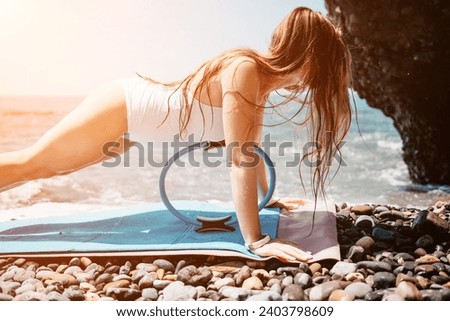 Woman sea fitness. Happy woman with long hair, fitness instructor in white bikini doing stretching and pilates on yoga mat near the sea. Female fitness yoga routine concept. Healthy lifestyle.