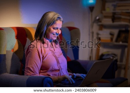 Senior woman sitting on the floor working on laptop