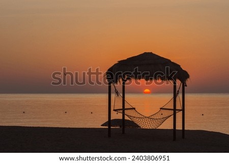 hammock with reed roof at the beach during sunrise in the morning