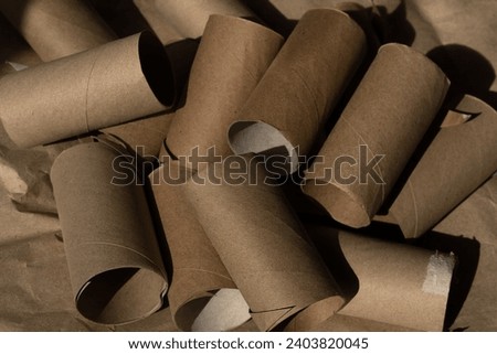 Used empty toilet paper rolls on a brown background. Royalty-Free Stock Photo #2403820045