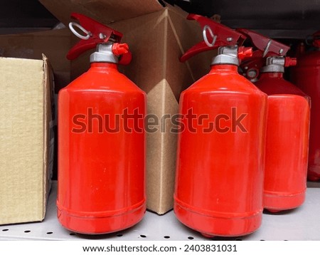Fire extinguisher on shelf in warehouse, closeup of photo.