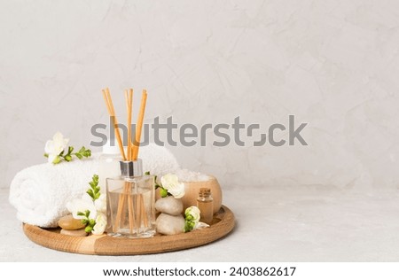 Aroma diffuser, burning candle, cherry blooming flowers and perfume on wooden bamboo tray. Cozy home decor, hygge and aromatherapy concept. Comfortable atmosphere, spring delicious fresh smell Royalty-Free Stock Photo #2403862617