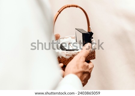 Detail of a priest holding the box with rings during a wedding celebration in the church. Traditional Catholic marriage. Open box with the groom's and bride's rings. Royalty-Free Stock Photo #2403865059