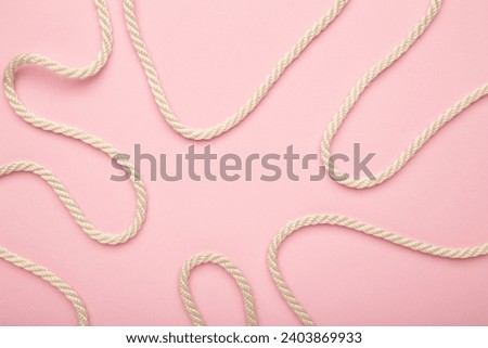 White wavy rope on pink background. Top view