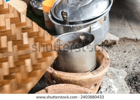 a picture showing the process of cooking kotok coffee in the traditional way, cooking with a brazier and aluminum pan