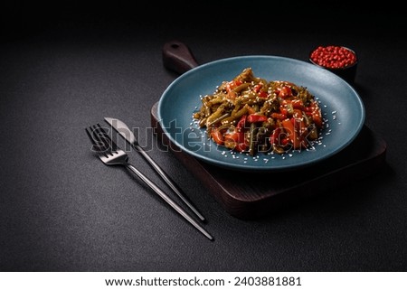 Mix of vegetables corn, carrots, peppers, broccoli, onions in teriyaki sauce on a ceramic plate on a dark concrete background