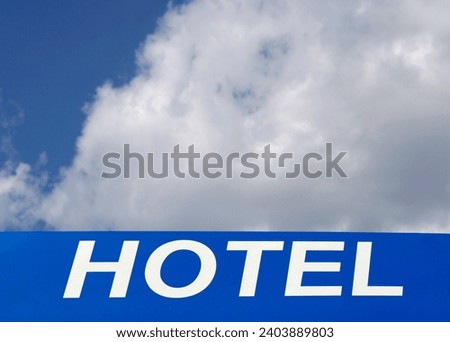 hotel sign against a cloudy sky
