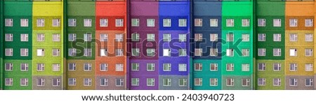 The wall of a multi-story building is painted in rainbow bright colors. Background for business, housing construction, sale, purchase, mortgage, rent. Colorful background.