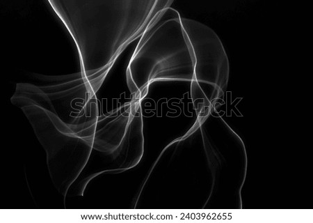 A shadow in a white translucent and weightless cape bowed its head, abstract photograph, created using intentional camera movements